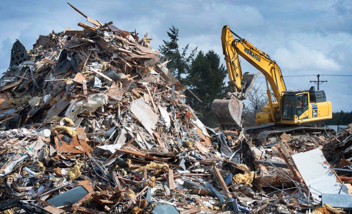 Workers continue the demolition of the former Narrows Bowl in University Place, Washington, on Tuesday, March 15, 2022.