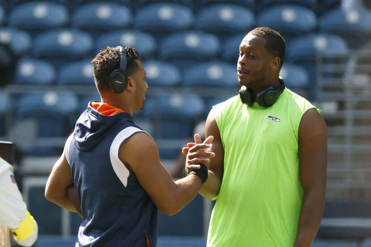 Sep 12, 2022; Seattle, Washington, USA; Denver Broncos quarterback Russell Wilson (left) shakes hands with Seattle Seahawks quarterback Geno Smith (7) during pregame warmups at Lumen Field. Mandatory Credit: Joe Nicholson-USA TODAY Sports