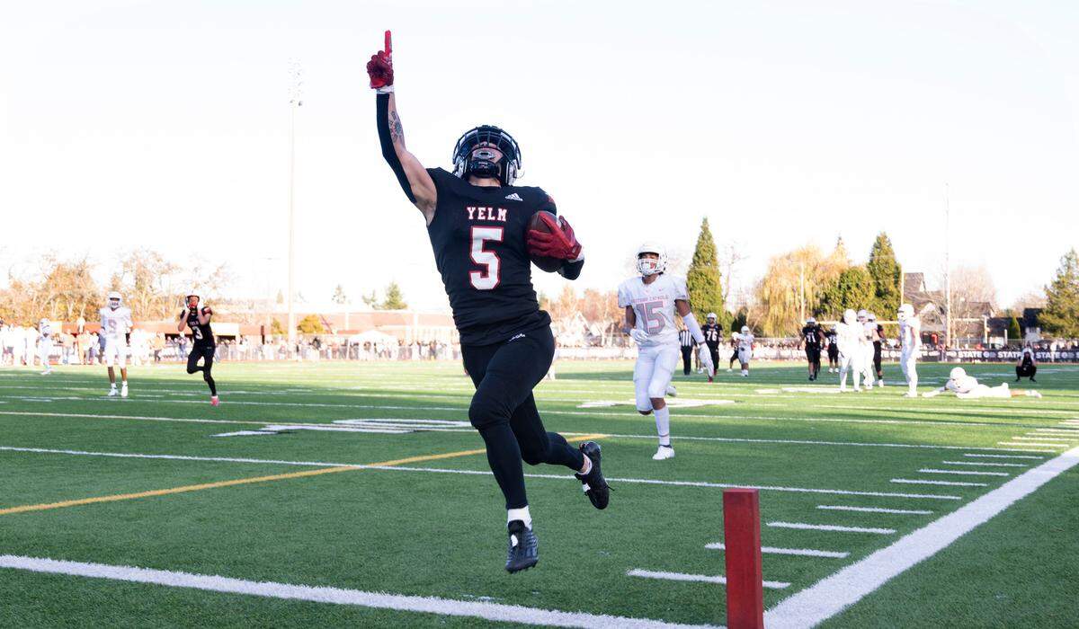 Yelm wide receiver Kyler Ronquillo streaks into the end zone after wrestling an interception away from Eastside Catholic defensive back Tyson Weaver, then carrying the football into the end zone for the game-winning touchdown, 20-13, in the 3A football state championship game at Sparks Stadium in Puyallup, Washington, on Saturday, Dec. 3, 2022.