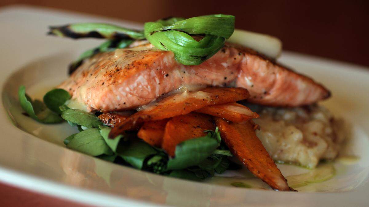 Brix 25 chef and owner Thad Lyman, offers the northwest influenced entree of pan seared king salmon with bacon risotto, peppercress, oven roasted carrot and a hazelnut beurre blanc, in Gig Harbor, July 30, 2010.