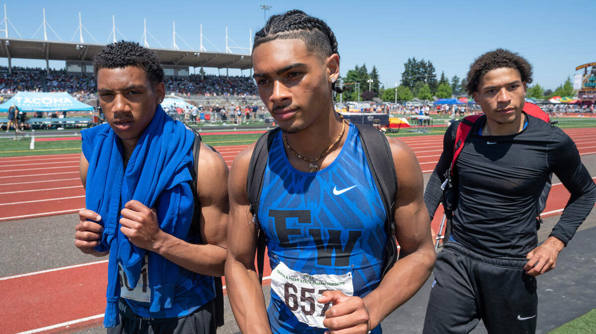 Federal Way teammates Jaylon Jenkins (from left), Julian Gene Fortin and Roman Hutchinson leave the field after sweeping the top three spots in the 4A boys triple jump competition during the second day of the WIAA state track and field championships at Mount Tahoma High School in Tacoma, Washington, on Friday, May 26, 2023. Hutchinson won the event, with Jenkins second and Fortin third.
