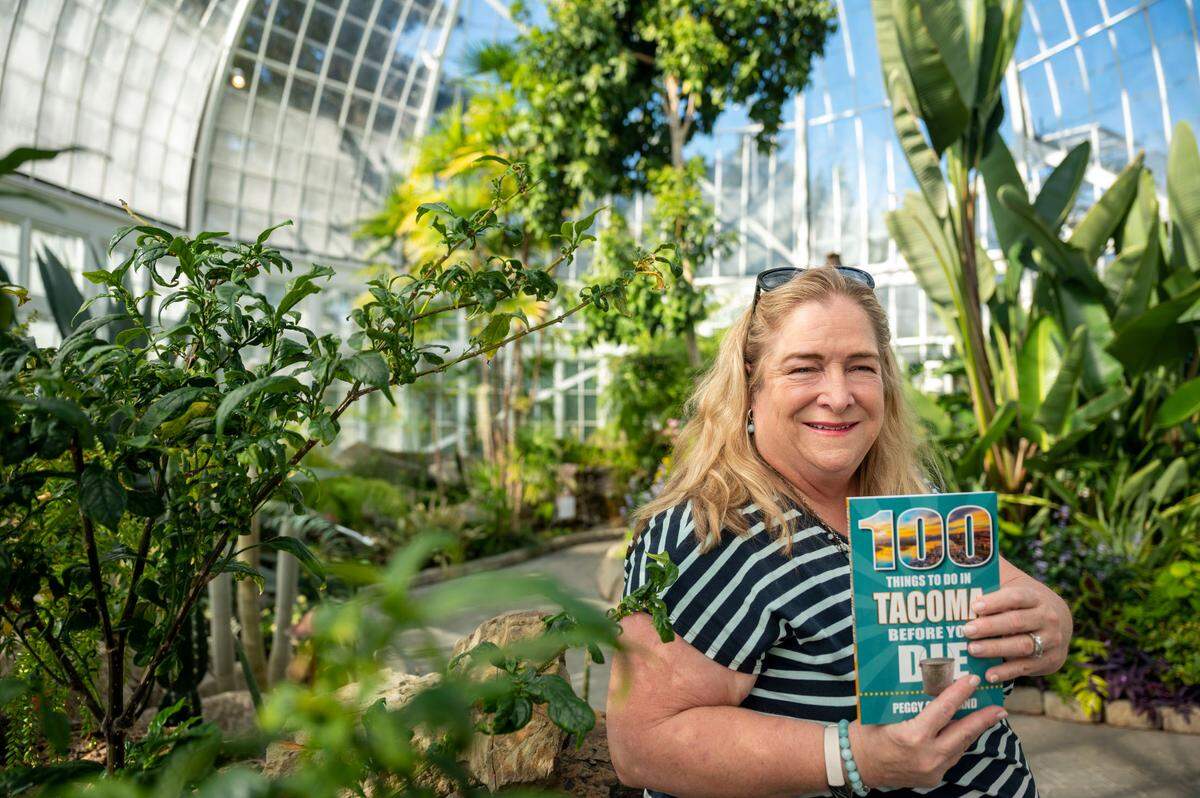 Steilacoom resident and retired military officer Peggy Cleveland has moved 33 times in her life, but when her family landed in Tacoma, “It just felt like home,” she said. She stands in the remodeled W.W. Seymour Conservatory, No. 79 in the book, on Oct. 13.