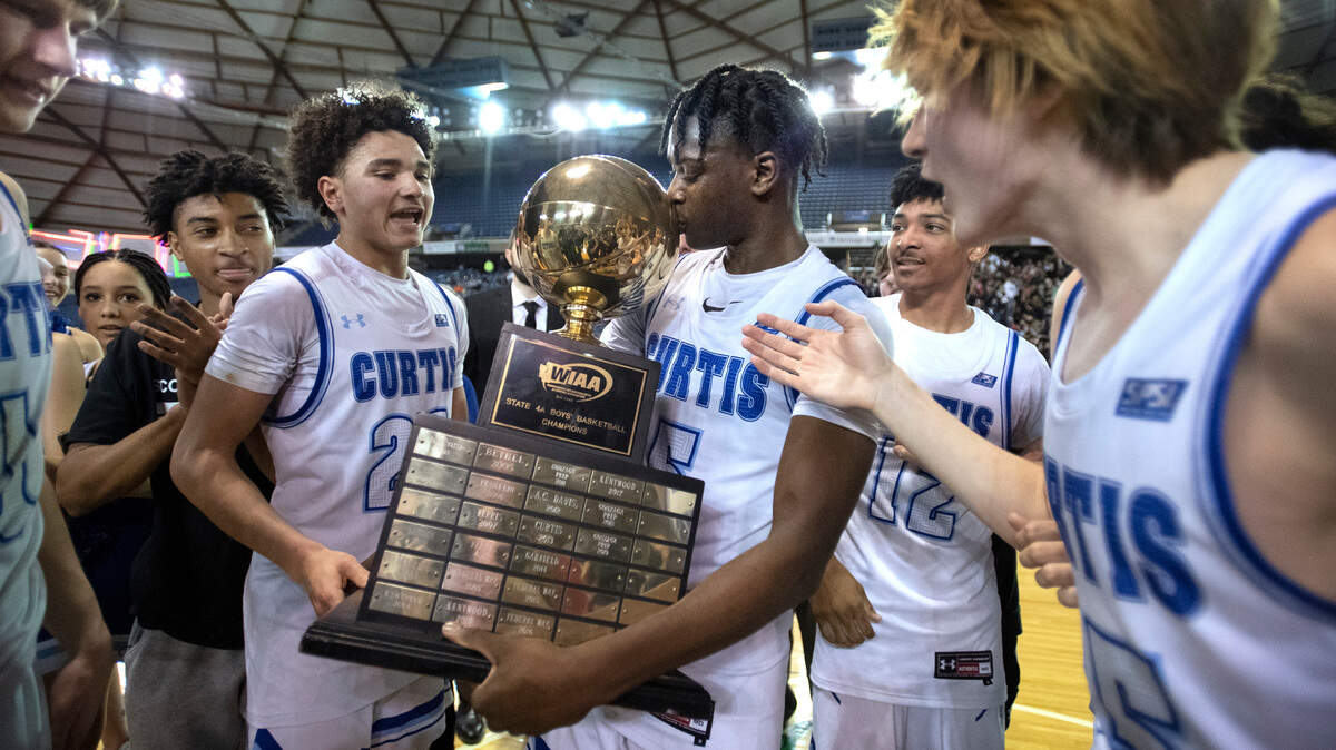 Curtis sophomore Zoom Diallo kisses the state championship trophy following the Vikings’ 52-49 overtime victory over the top-ranked Mount Si Wildcats in the WIAA 4A Boys Basketball State Championship game in the Tacoma Dome in Tacoma, Washington, on Saturday, March 5, 2022.