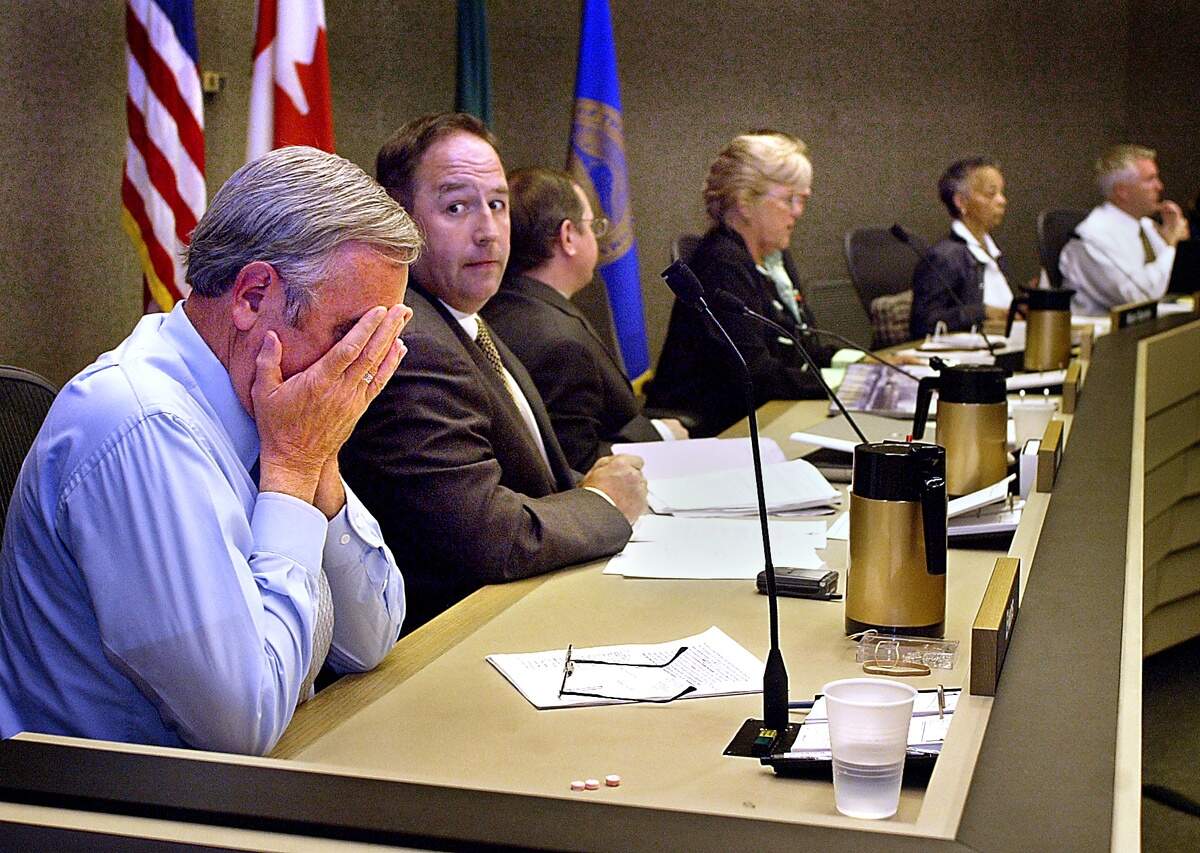Ending an emotional chapter in Tacoma city history, Tacoma City Councilmen Bill Evans buries his head in his hands after a 5-4 vote by the council ended the career of Ray Corpuz as Tacoma City Manager. Evans voted to remove Corpuz along with Councilmen Rick Talbert, second from left, that day in 2003.