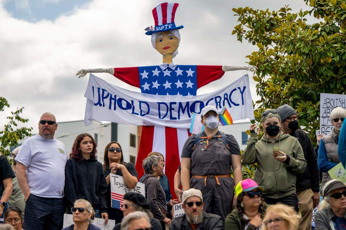 People gather at People’s Park in the Hilltop neighborhood of Tacoma to listen to speakers during a No Kings protest on June 14, 2025.