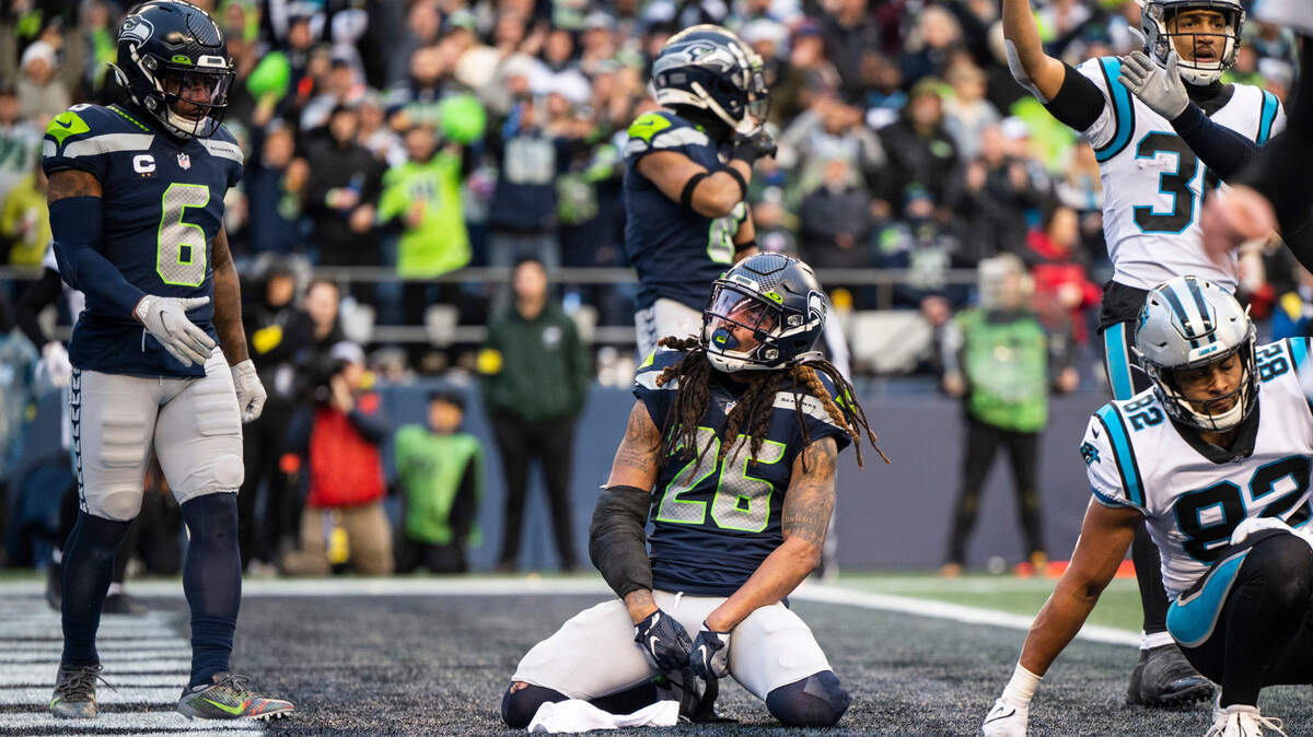 Seattle Seahawks safety Ryan Neal (26) kneels after tackling Carolina Panthers tight end Tommy Tremble (82) near the end zone in the second quarter of an NFL game at Lumen Field in Seattle Wash., on Dec. 11, 2022. The Seahawks lost to the Panthers 24-30.