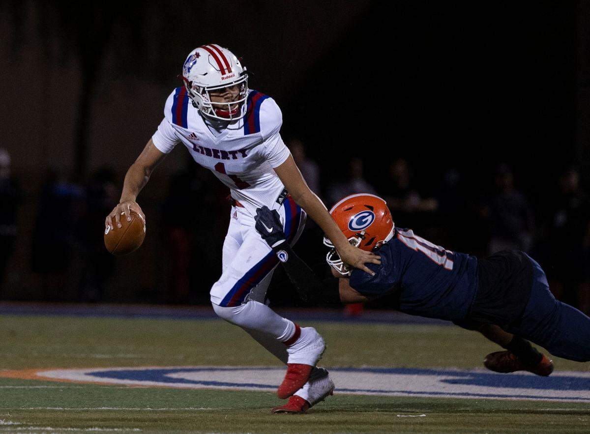 Liberty High School quarterback Jayden Maiava (1) tackled by Bishop Gorman’s Cyrus Moss (11) during the first half of a Class 5A state semifinal football game at Bishop Gorman High School, on Friday, Nov. 12, 2021, in Las Vegas.