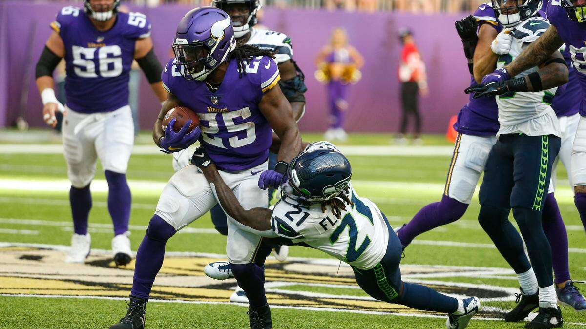 Minnesota Vikings running back Alexander Mattison (25) is tackled by Seattle Seahawks cornerback Tre Flowers (21) in the first half of an NFL football game in Minneapolis, Sunday, Sept. 26, 2021. (AP Photo/Bruce Kluckhohn)