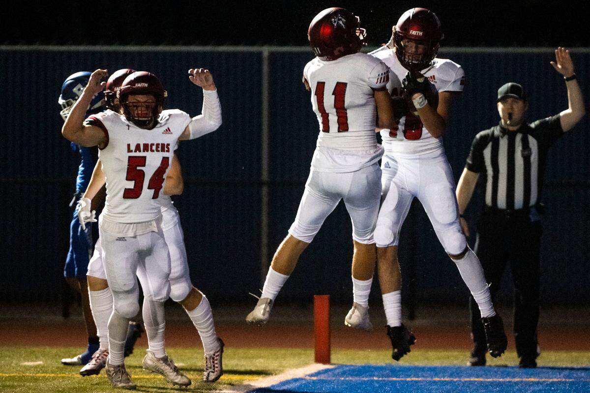 Kennedy Catholic’s Dante Saldino celebrates with Thomas Bevilacqua after Saldino intercepted a pass by Federal Way quarterback Jay O’Neil during the first quarter of a 4A NPSL game on Friday, Sept. 30, 2022, at Federal Way Memorial Field in Federal Way, Wash.