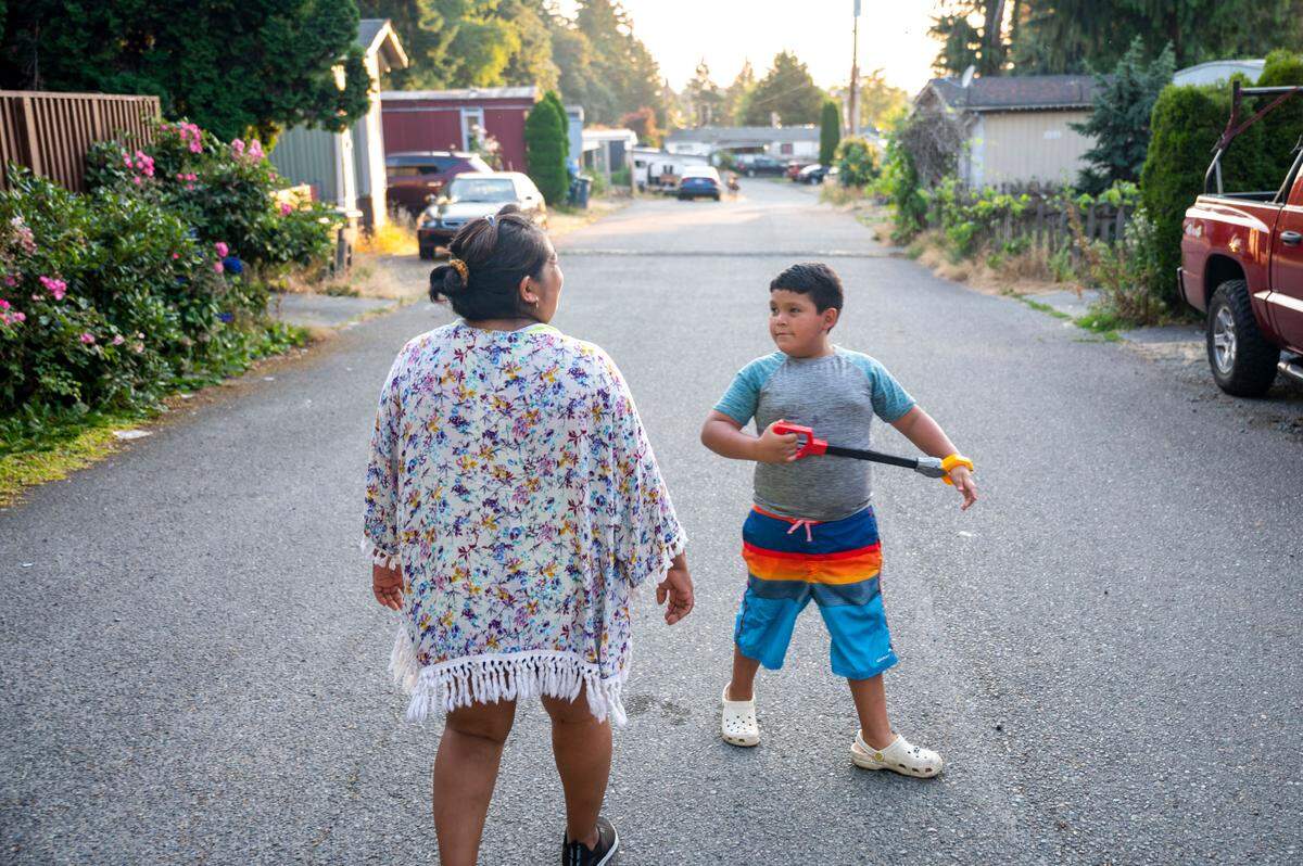 Saraim Nieto walks down the main street of Meridian Estates with her son, Sergio Calderon, on Wednesday, July 27, 2022, in Puyallup, Wash.
