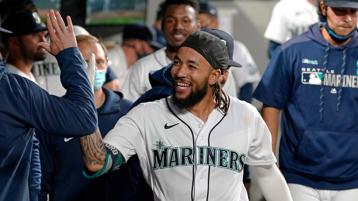 Seattle Mariners’ J.P. Crawford smiles while being congratulated by teammates after his solo home run against the Texas Rangers during the seventh inning of a baseball game Saturday, May 29, 2021, in Seattle. (AP Photo/Elaine Thompson)