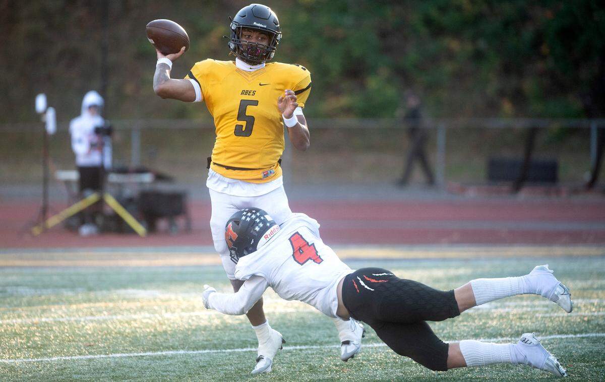 Lincoln quarterback Gabarri Johnson fires a pass under pressure from Monroe defensive back Gavin Ranz during Saturday afternoon’s 3A state football playoff game at Lincoln Bowl in Tacoma, Washington, Nov. 12, 2022. Lincoln won the game, 49-16.