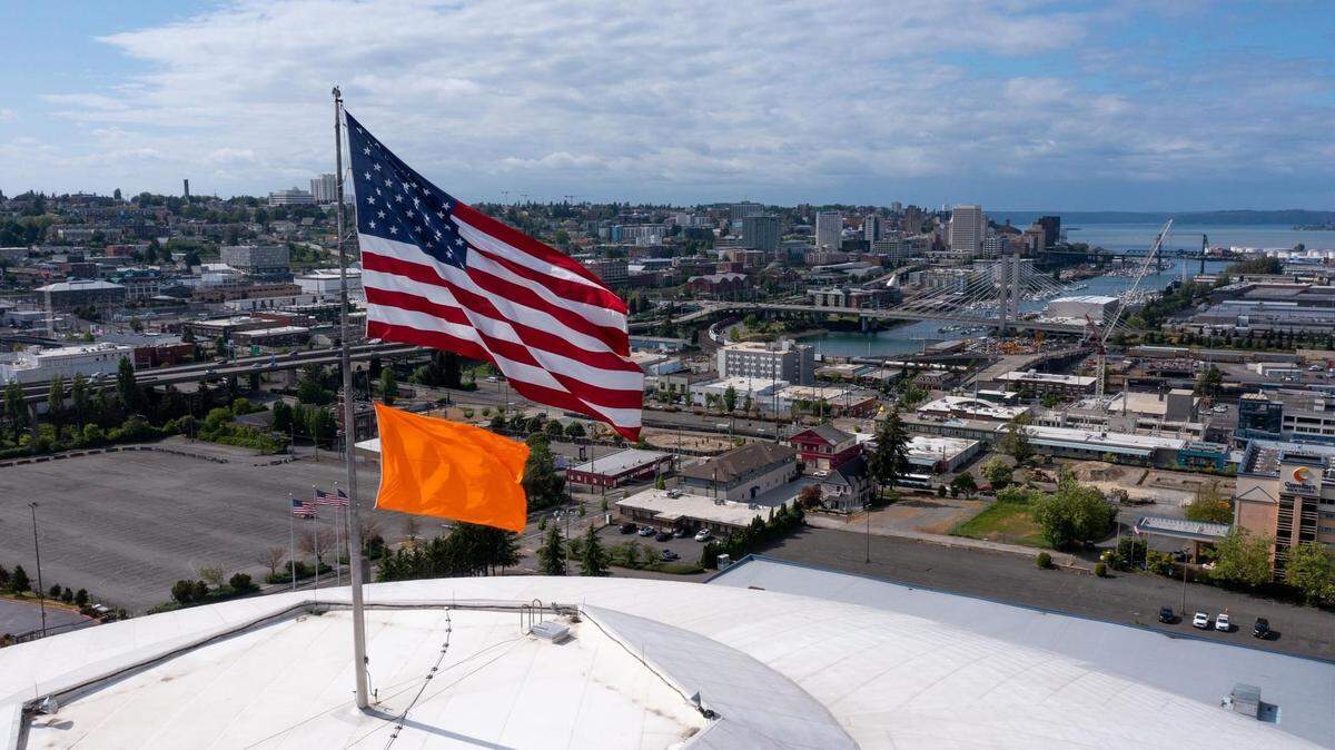 An orange flag flies on top of the Tacoma Dome earlier this spring.