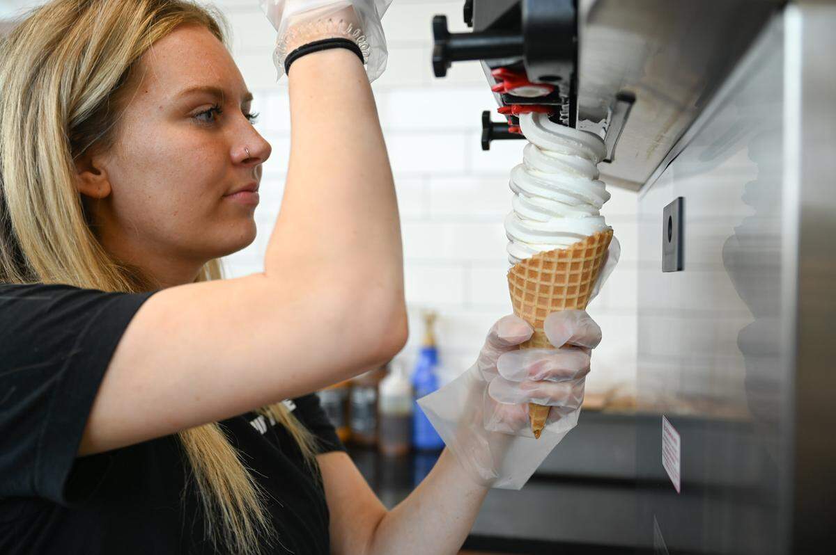 Kylee Fletcher, 19, of Enumclaw, prepares a vanilla soft-serve in a waffle cone at The Mount Rainier Creamery & Market, now open in Buckley.