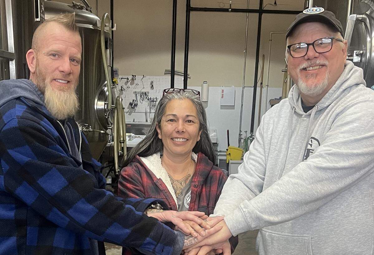 Matt Burnett (left), John Fosberg (right) and a friend pictured Friday, Jan. 31, 2025 celebrate Evergreen State Brewing’s purchase of Gig Harbor Brewing.