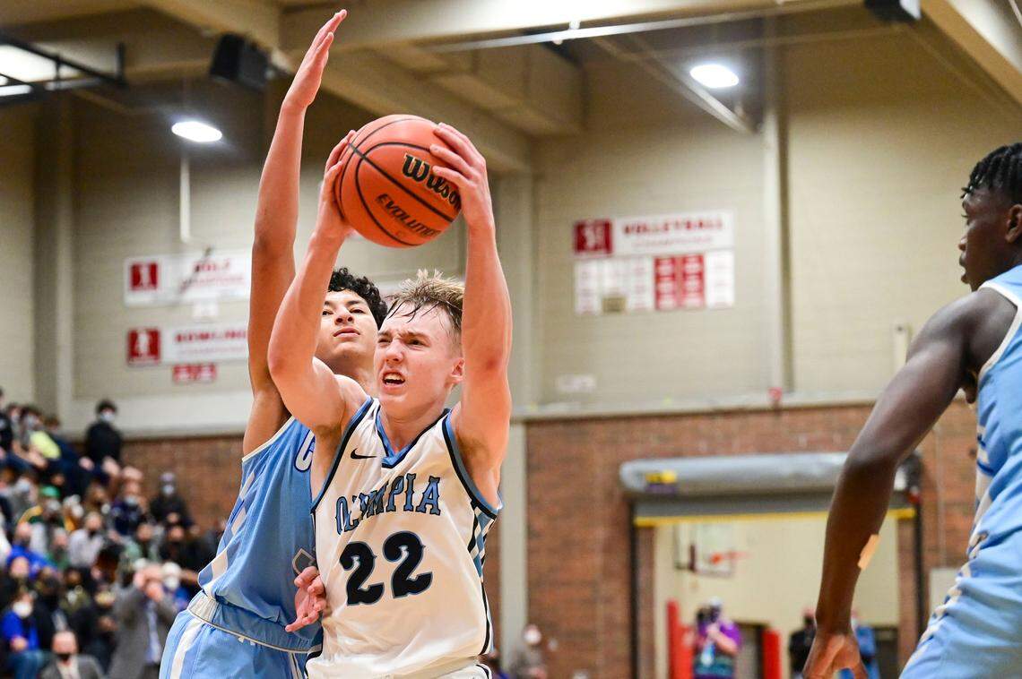 Olympia guard Parker Gerrits (22) drives to the basket as Curtis guard Devin Whitten (3) defends during the third quarter of a 4A South Puget Sound League tournament championship game on Saturday, Feb. 5, 2022, at Bethel High School in Spanaway, Wash.