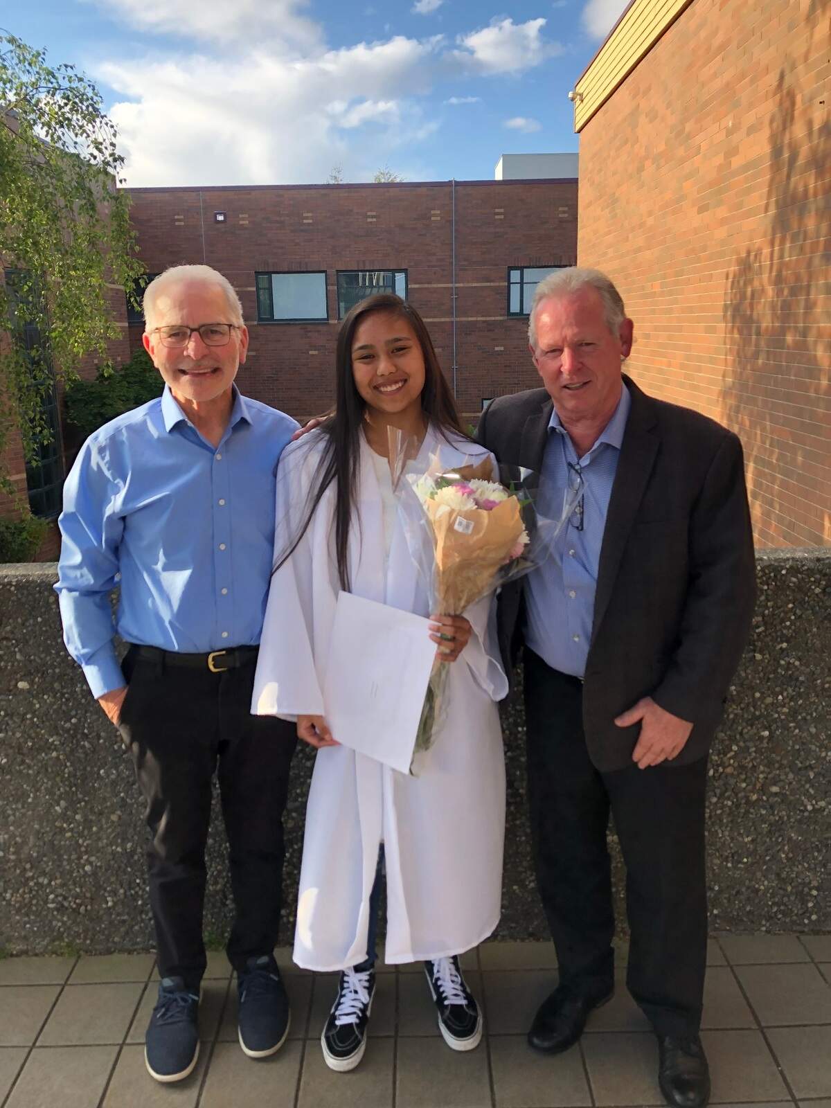 Bill Kombol, left, and Steve Beck, right, presented Curtis Senior graduate Alana Penamante with a $10,000 scholarship May 23, 2022.