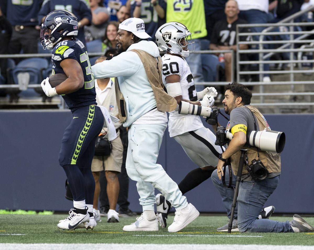 Seattle Seahawks running back George Holani (36) bounces off former Seahawks running back Marshawn Lynch after scoring a touchdown during the first quarter of the game against the Las Vegas Raiders at Lumen Field, on Thursday, Aug. 7, 2025, in Seattle, Wash.