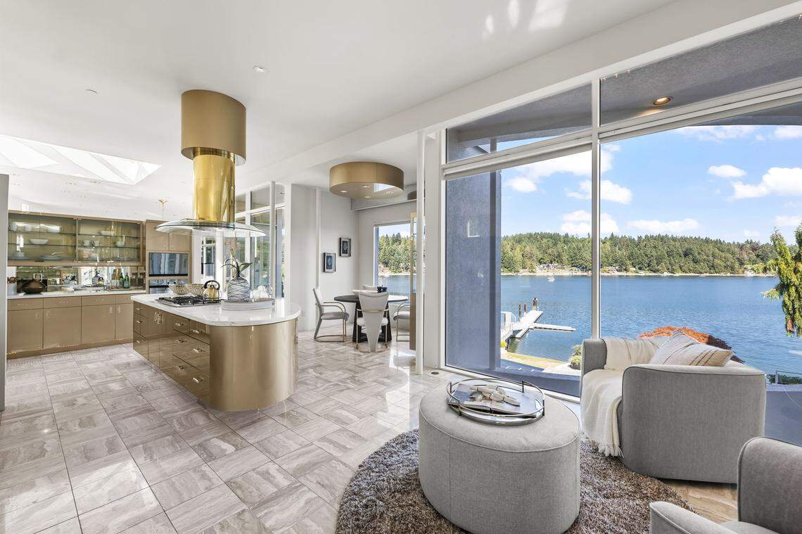 The kitchen features a gold-plated range vent, gold-accented lucite cabinetry and marble counters in The S House near Gig Harbor, Wash.