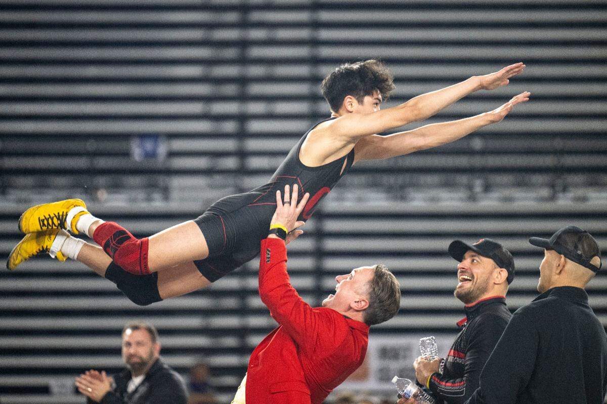 Orting’s A.J. Salguero leaps into the arms of head coach Jody Coleman after beating Centralia’s Jesus Campos in the Class 2A 120-pound championship match at Mat Classic XXXIV on Saturday, Feb. 18, 2023, at the Tacoma Dome in Tacoma, Wash. Salguero beat Campos, 6-1.