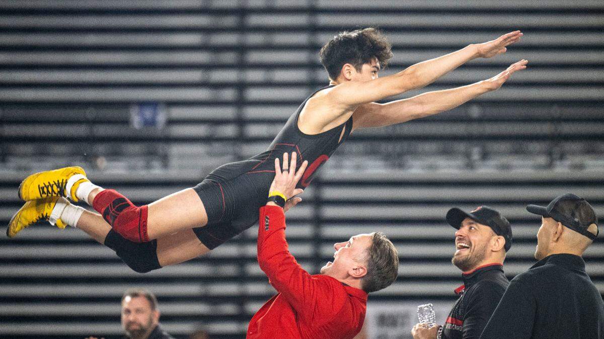 Orting’s A.J. Salguero leaps into the arms of head coach Jody Coleman after beating Centralia’s Jesus Campos in the Class 2A 120-pound championship match at Mat Classic XXXIV on Saturday, Feb. 18, 2023, at the Tacoma Dome in Tacoma, Wash. Salguero beat Campos, 6-1.