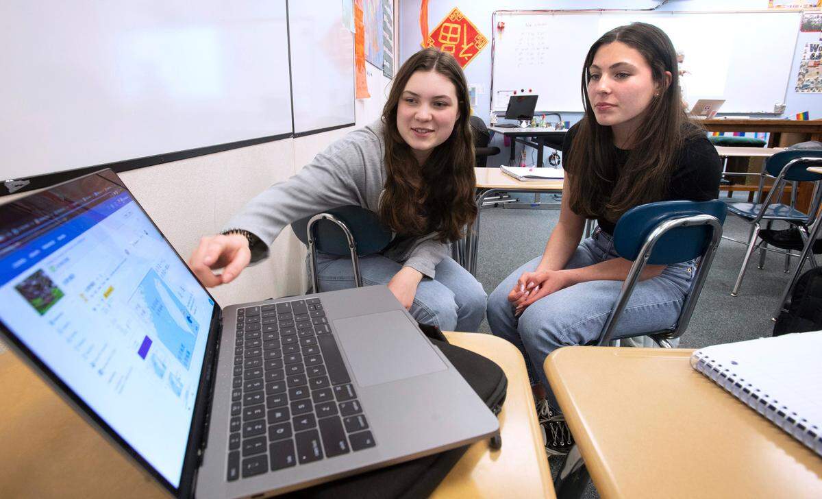 Gig Harbor sophomores Sasha Unger (left), 16, and Mia Morente, 15, look over a map of Taiwan during their Chinese language class at Gig Harbor High School in Gig Harbor, Washington, on Thursday, March 31, 2022.