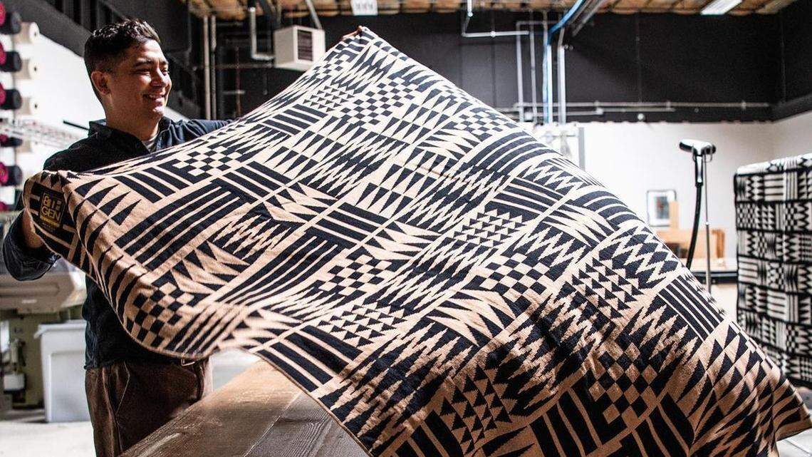 Nooksack artist Louie Gong, founder of Native-owned art and lifestyle brand Eighth Generation, displays a Coast Salish pattern blanket.
