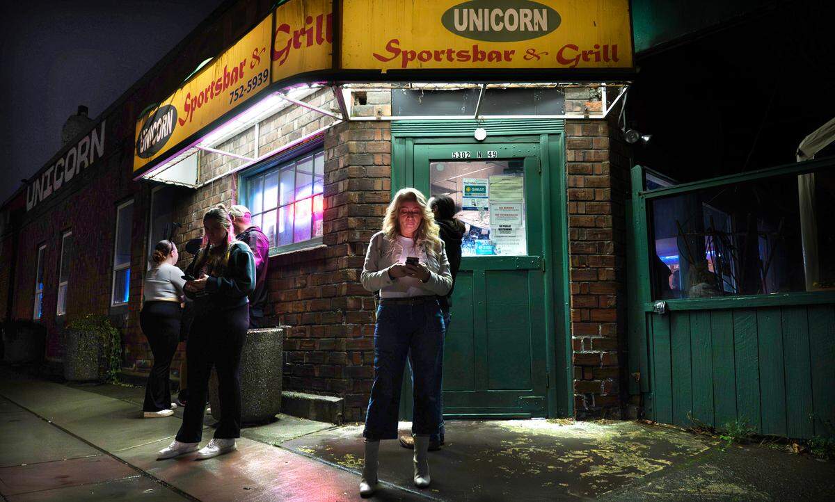 Jennifer Johnson joins others for a break outside at the Unicorn Sports Bar & Grill in Ruston, Washington, Friday, Oct. 25, 2024.
