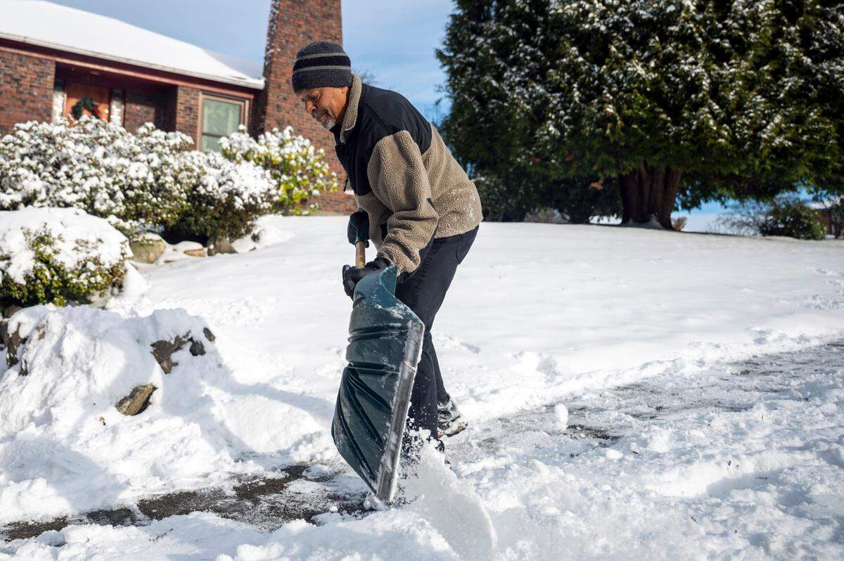 Bobby Jones shovels snow from the sidewalk in front of his house on East 54th Street in Tacoma on Monday morning.