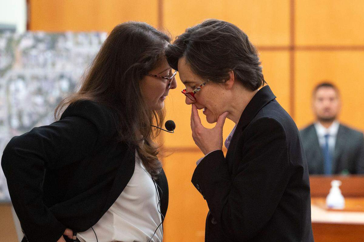 State assistant attorneys general Barbara Serrano (left) and Melanie Tratnik talk about a line of questioning while former Tacoma Police Department officer Corey Ventura sits on the witness stand on Thursday, Dec. 1, 2022, at Pierce County District Court in Tacoma.