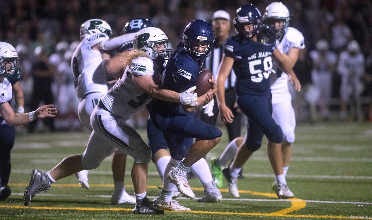 Gig Harbor quarterback Will Landram is wrapped up by Penisula defensive lineman Grady Johnson to prevent a game-tying two-point conversion during Friday night’s Fish Bowl crosstown rivalry football game at Roy Anderson Field in Purdy, Washington, on Sept. 16, 2022. Peninsula won the game, 39-30.