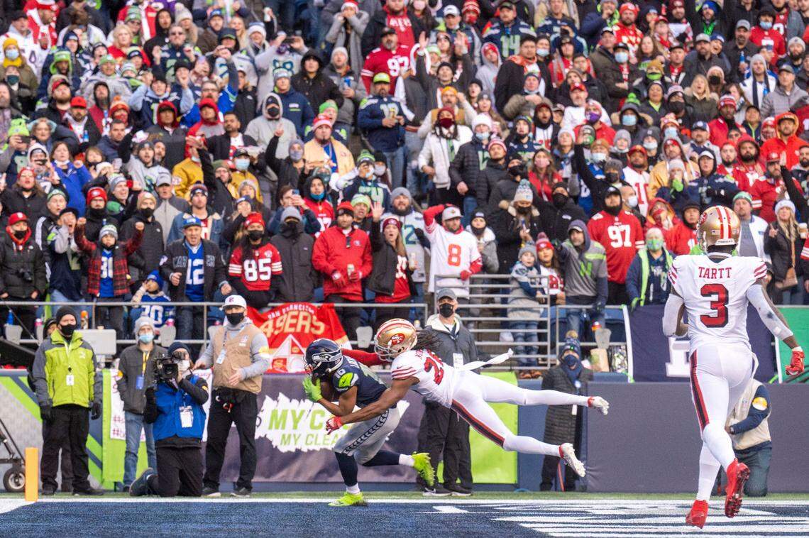 Seattle Seahawks wide receiver Tyler Lockett (16) pulls in a touchdown pass from quarterback Russell Wilson (3) as San Francisco 49ers cornerback Josh Norman (26) defends during the third quarter of an NFL game on Sunday at Lumen Field in Seattle.