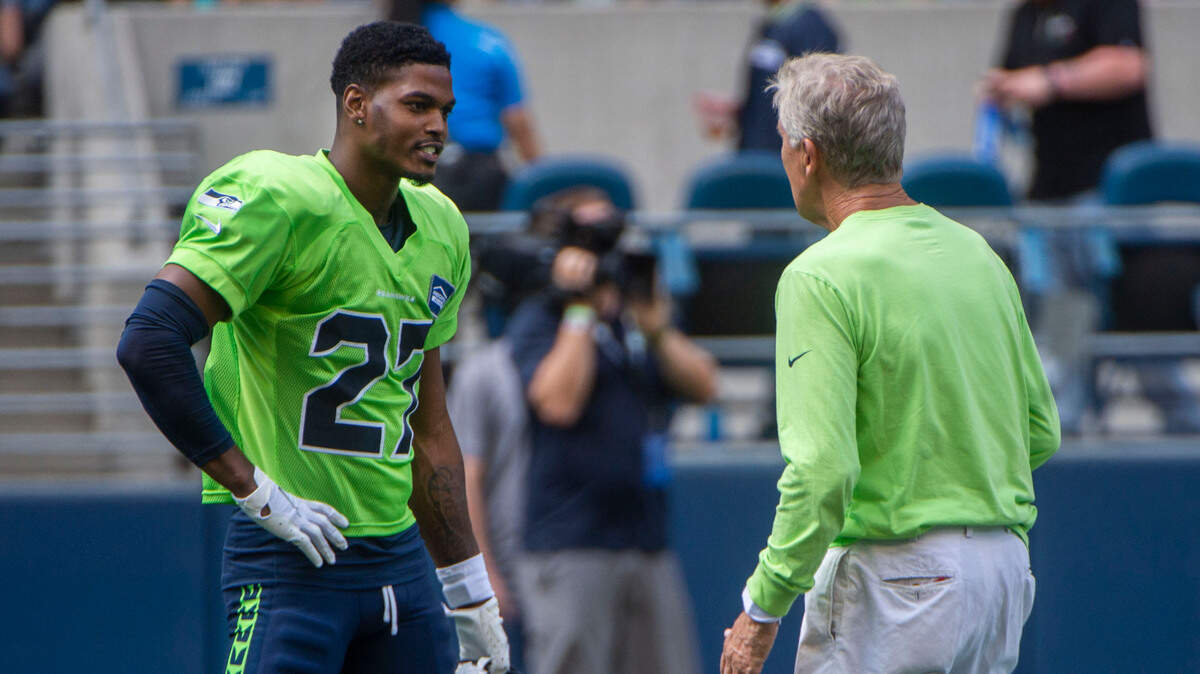 Seahawks safety Marquise Blair, left, chats with coach Pete Carroll prior to the annual training camp mock game at Lumen Field in Seattle on August, 5, 202.