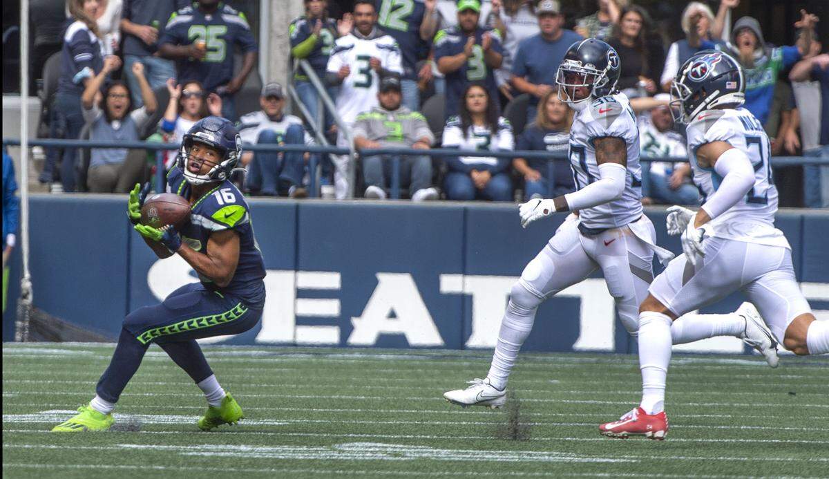 Seahawks receiver Tyler Lockett hauls in a pass and eludes Titans defenders Elijah Molden and Bradley McDougald to race in for a 63-yard touchdown in the first half which made the score 9-3 in favor of Seattle at Lumen Field on Sunday, Sept. 19, 2021.