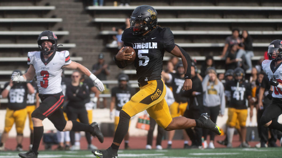 Lincoln quarterback Gabarri Johnson breaks loose for the first of two touchdown runs against the Camas Papermakers in Saturday afternoon’s 4A football game at Lincoln Bowl in Tacoma, Washington, on Sept. 17, 2022. Lincoln won the game, 42-28.