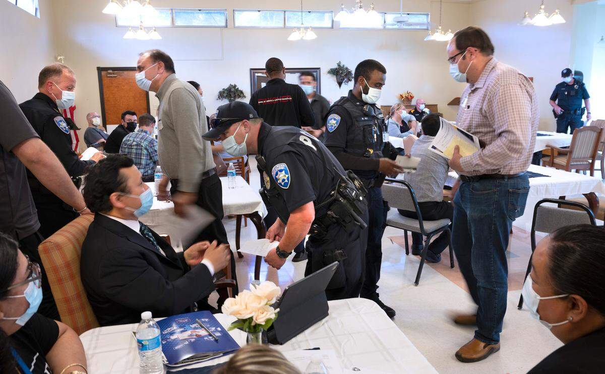 Tacoma police officers talk with business operators concerned for their safey at the Hosmer Business Association meeting on Hosmer Street in Tacoma, Washington on June 22, 2022.
