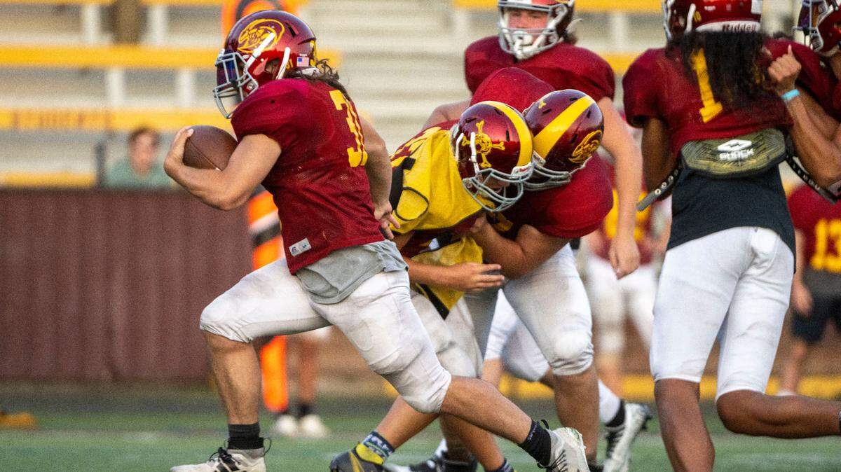 With the help of a block from offensive lineman Zeke Luchi (center), Enumclaw running back Emmit Otero is off to the races during team drills on Wednesday, Aug. 24, 2022, in Enumclaw, Wash.