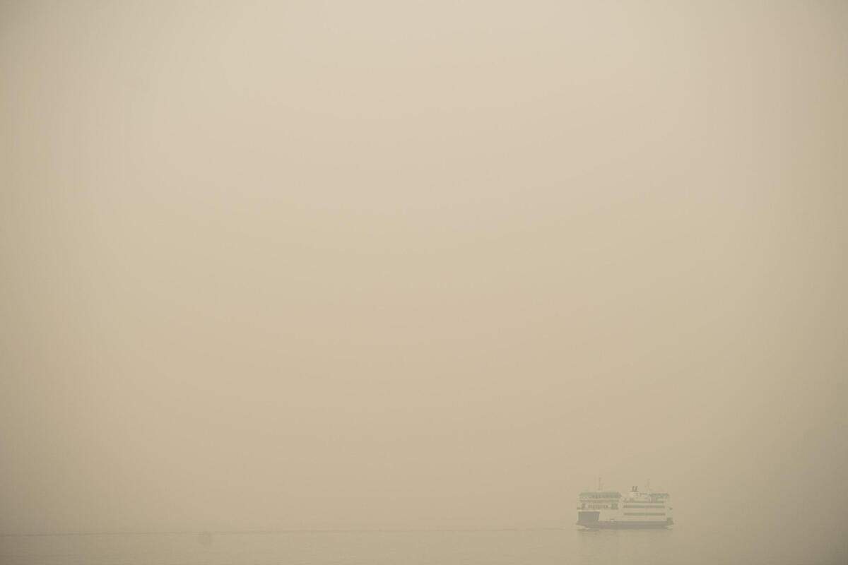 A Washington State ferry travels through the heavy smoke blanketing Tacoma, Wash., on Saturday, Sept. 12, 2020.