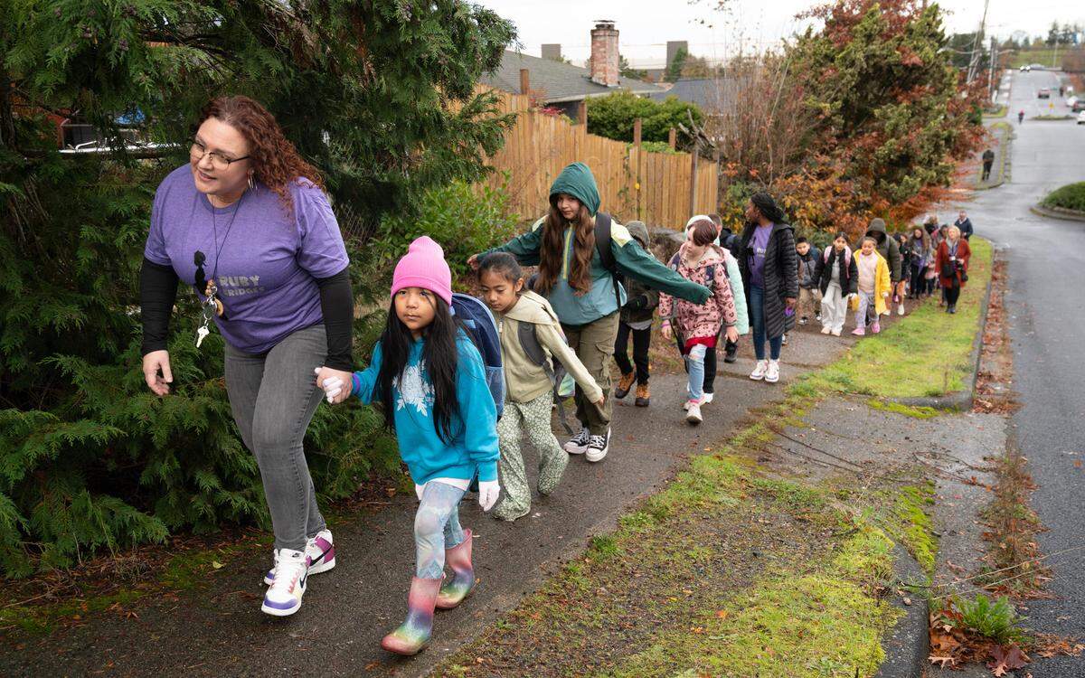 Megan Clark leads Birney Elementary students on their morning walk to school as they celebrate Ruby Bridges Day in southeast Tacoma on Thursday, Nov. 14, 2024.