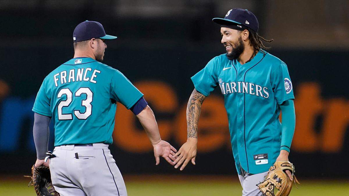 Seattle Mariners’ Ty France, left, celebrates with J.P. Crawford after the Mariners defeated the Oakland Athletics in a baseball game in Oakland, Calif., Monday, Sept. 20, 2021. (AP Photo/Jeff Chiu)
