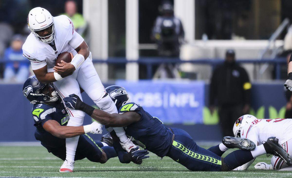 Seattle Seahawks safety Nick Emmanwori (3) and defensive end DeMarcus Lawrence (0) sack Arizona Cardinals quarterback Jacoby Brissett (7) for a 6-yard loss during the second quarter of the game at Lumen Field, on Sunday, Nov. 9, 2025, in Seattle.