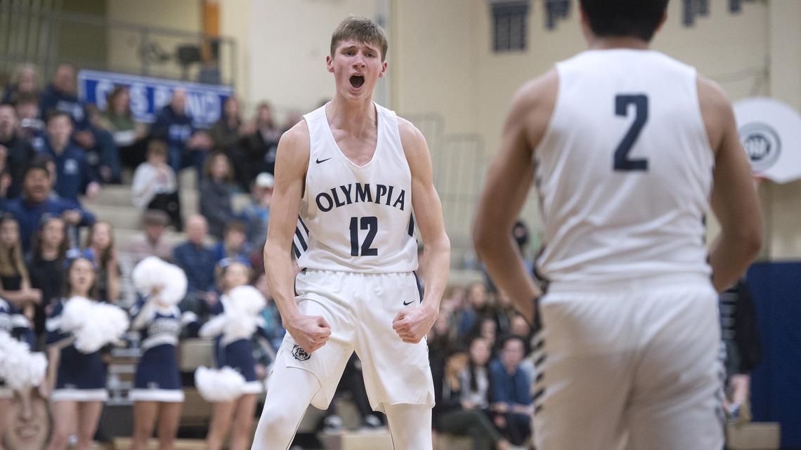 Olympia sophomore forward Jackson Grant flexes his muscles after scoring and drawing a foul during the Bears’ 60-55 overtime victory over the Puyallup Vikings in Friday night’s SPSL boys basketball game at Olympia High School on Jan. 25, 2019.