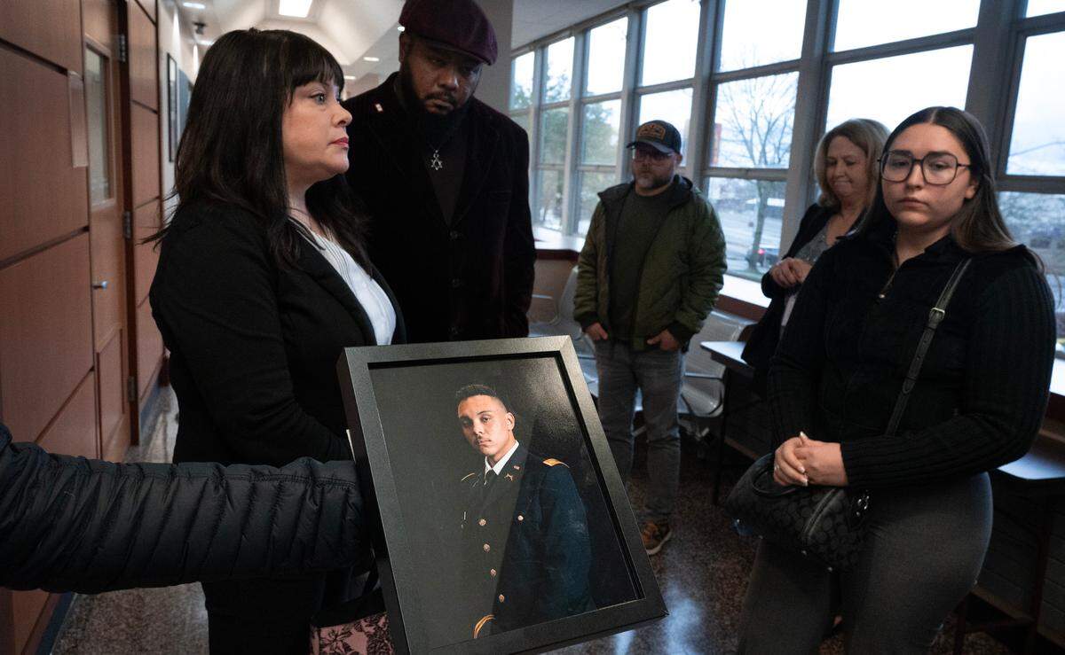 The family of National Guard officer Rudolph King III shares a photo following the arraignment of his accused murderer, Andrew Fonoti, in Pierce County Superior Court in Tacoma, Washington, on Friday, Dec. 22, 2023. Fonoti was arraigned on charges of first-degree murder and other counts in the shooting death of King in September.