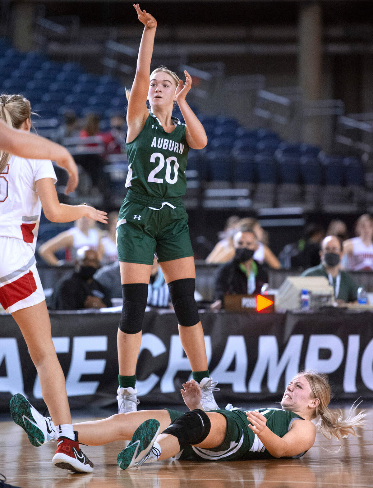 Auburn’s Chloe Furnstahl puts up a jumper as teammate Rachel Crook is knocked to the ground by a Stanwood defender during Wednesday afternoon’s opening-round game of the WIAA 3A Girls Basketball State Championships tournament in the Tacoma Dome in Tacoma, Washington, on Wednesday, March 2, 2022. Auburn lost to Stanwood, 53-39.
