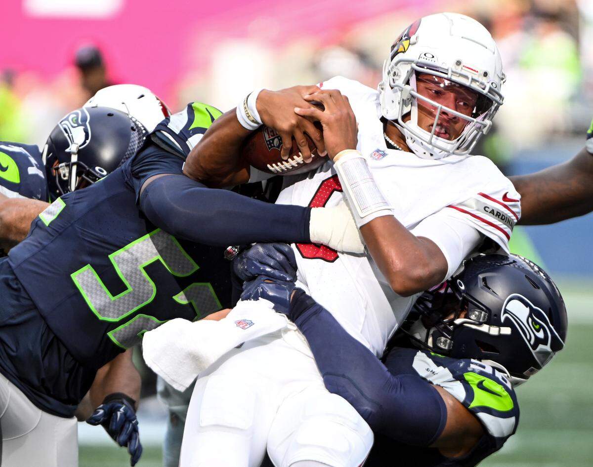 Seattle Seahawks linebacker Darrell Taylor (52) and linebacker Bobby Wagner (54) combine for a hit on Arizona Cardinals quarterback Joshua Dobbs (9) during the third quarter of the game at Lumen Field, Sunday, Oct. 22, 2023, in Seattle, Wash.