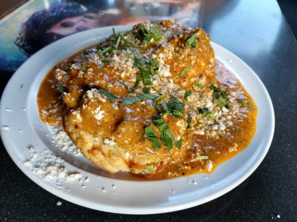 Chorizo gravy tops a split-open housemade jalapeno cheddar biscuit from The Church Cantina.