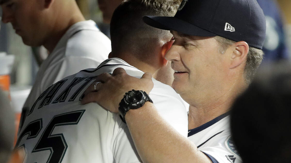 Seattle Mariners starting pitcher James Paxton, left, is hugged in the dugout by manager Scott Servais, right, after Paxton finished the sixth inning of a baseball game against the Houston Astros, Monday, July 30, 2018, in Seattle. (AP Photo/Ted S. Warren)