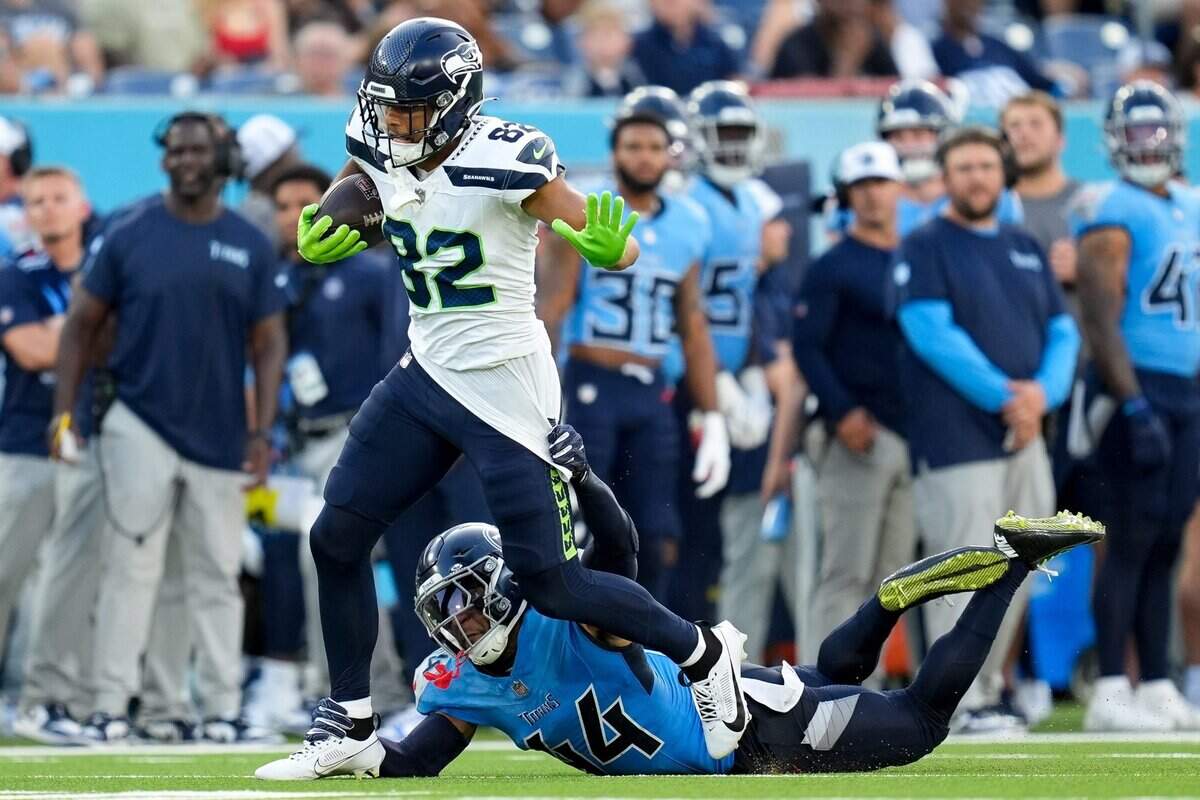 Seattle Seahawks wide receiver Cody White (82) is pulled down by Tennessee Titans safety Mike Brown (44) during the second quarter at Nissan Stadium in Nashville, Tenn., Saturday, Aug. 17, 2024.