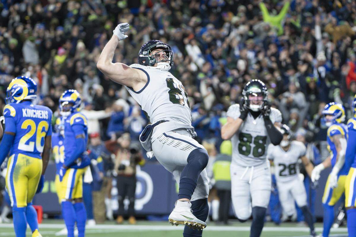 Seattle Seahawks tight end Eric Saubert (81) raises the ball in celebration of his two point conversion, winning the game against the Los Angeles Rams in overtime at Lumen Field, on Thursday, Dec. 18, 2025, in Seattle.
