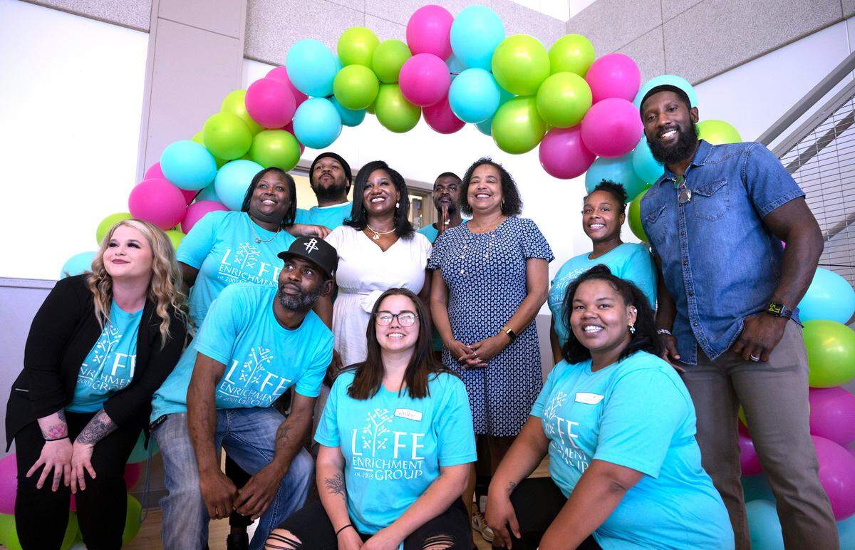 Former Seattle Seahawk Marcus Trufant (far right) joins Tacoma Mayor Victoria Woodards (center right) and staff of Life Enrichment Group during the public tour of the group’s new expanded homeless youth services at the Beacon Center in Tacoma on Wednesday, July 20, 2022.